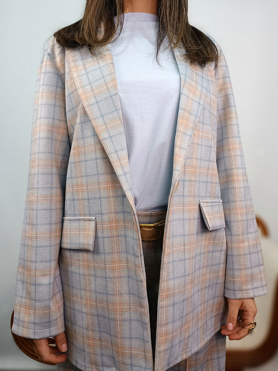 Detalle del tejido y estampado de la blazer de cuadros azul y rosa.