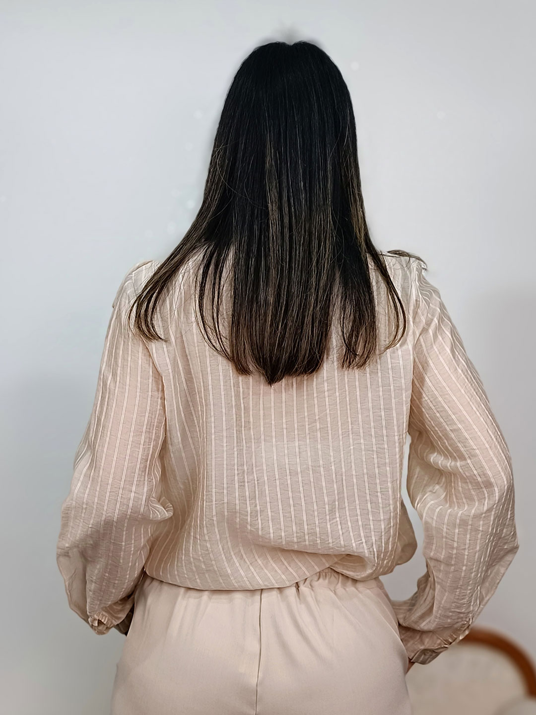 Vista trasera de la espalda de la blusa romántica beige mujer.