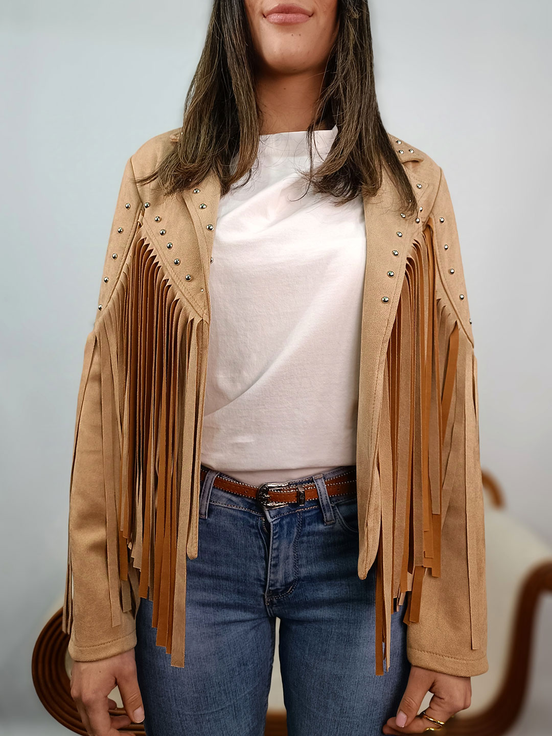 Detalle macro de las tachuelas y el tejido de la chaqueta de flecos camel mujer.