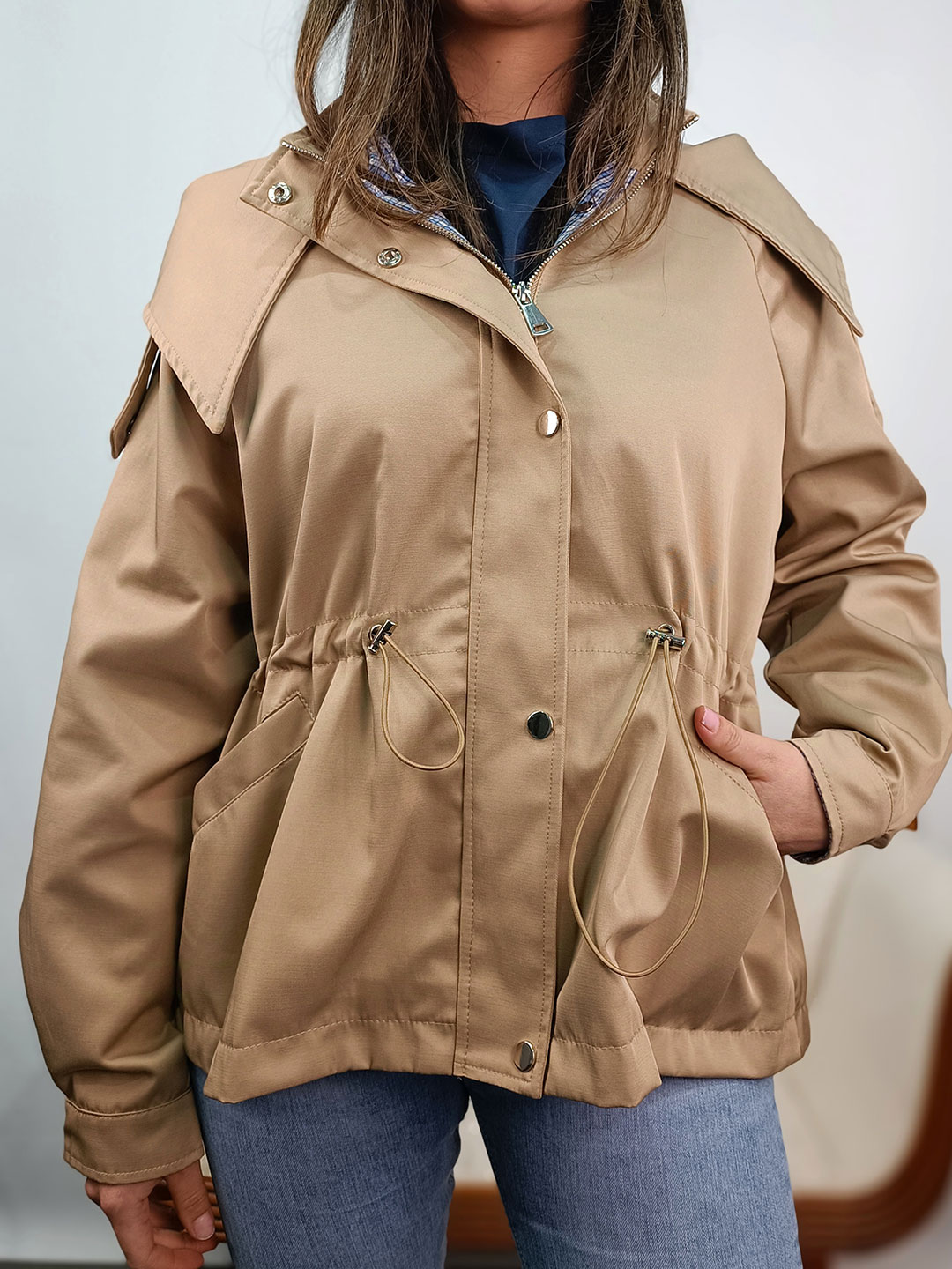Detalle de botones, cremallera y tejido de la parka corta camel mujer.