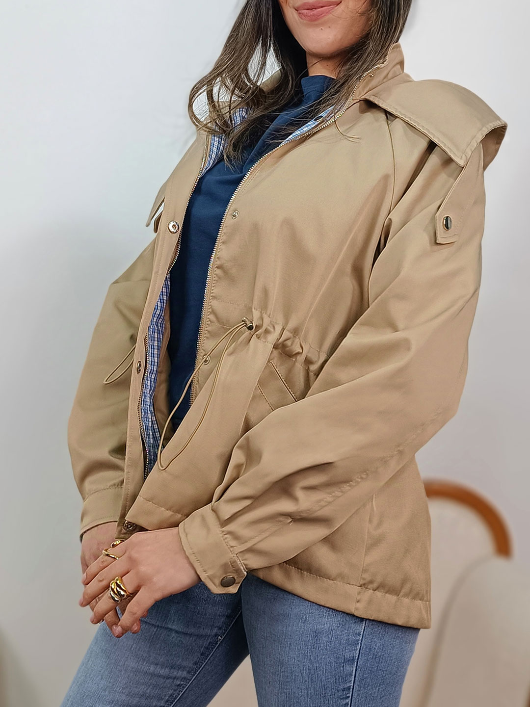 Perfil de parka corta camel mujer resaltando el cordón ajustable.