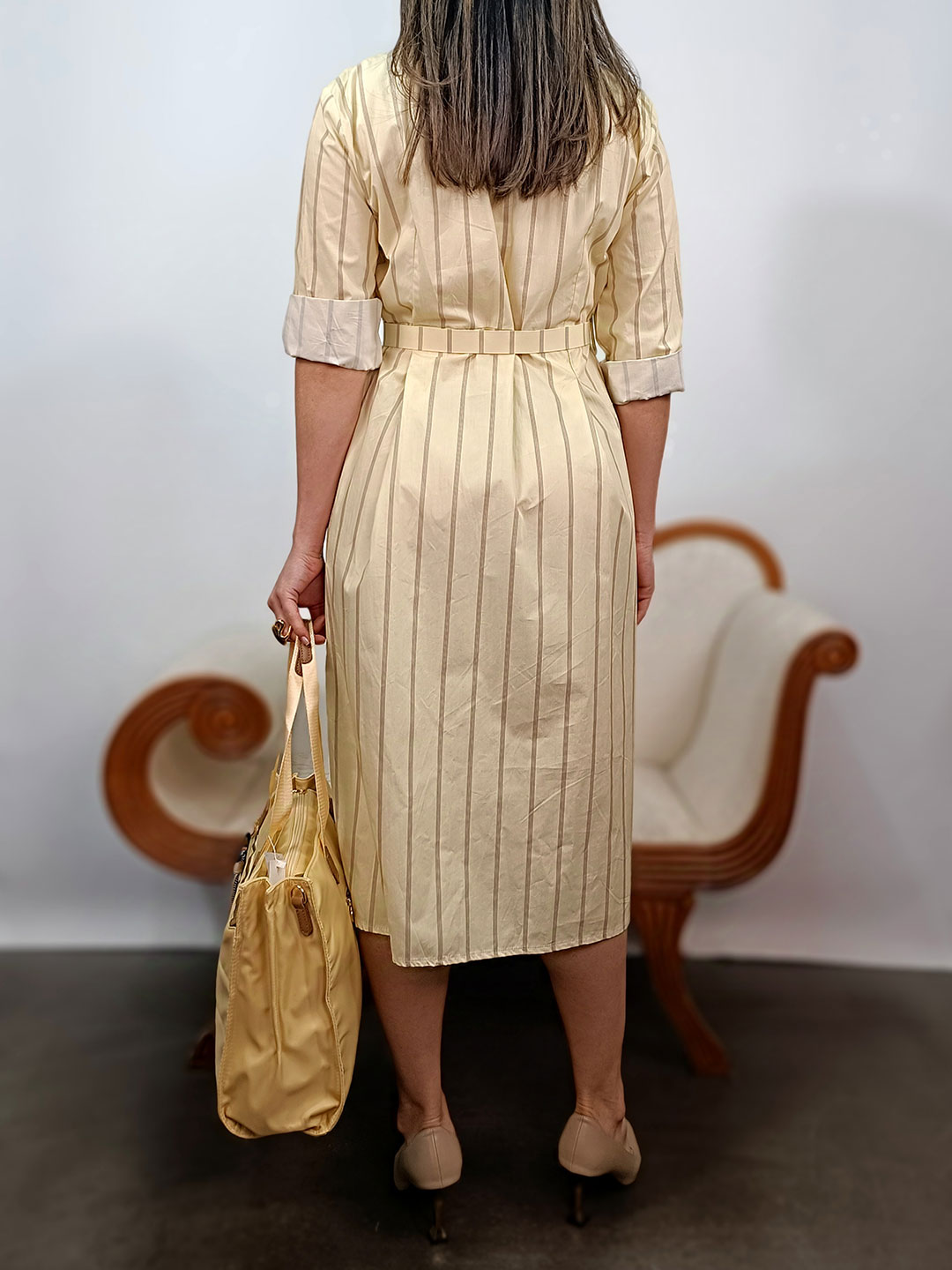 Espalda del vestido midi camisero de rayas amarillo con talle ajustado.