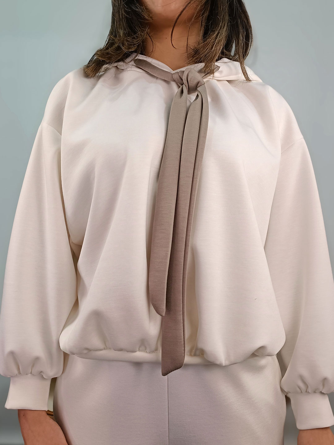 Primer plano de la lazada topo y el cuello del conjunto chándal blanco