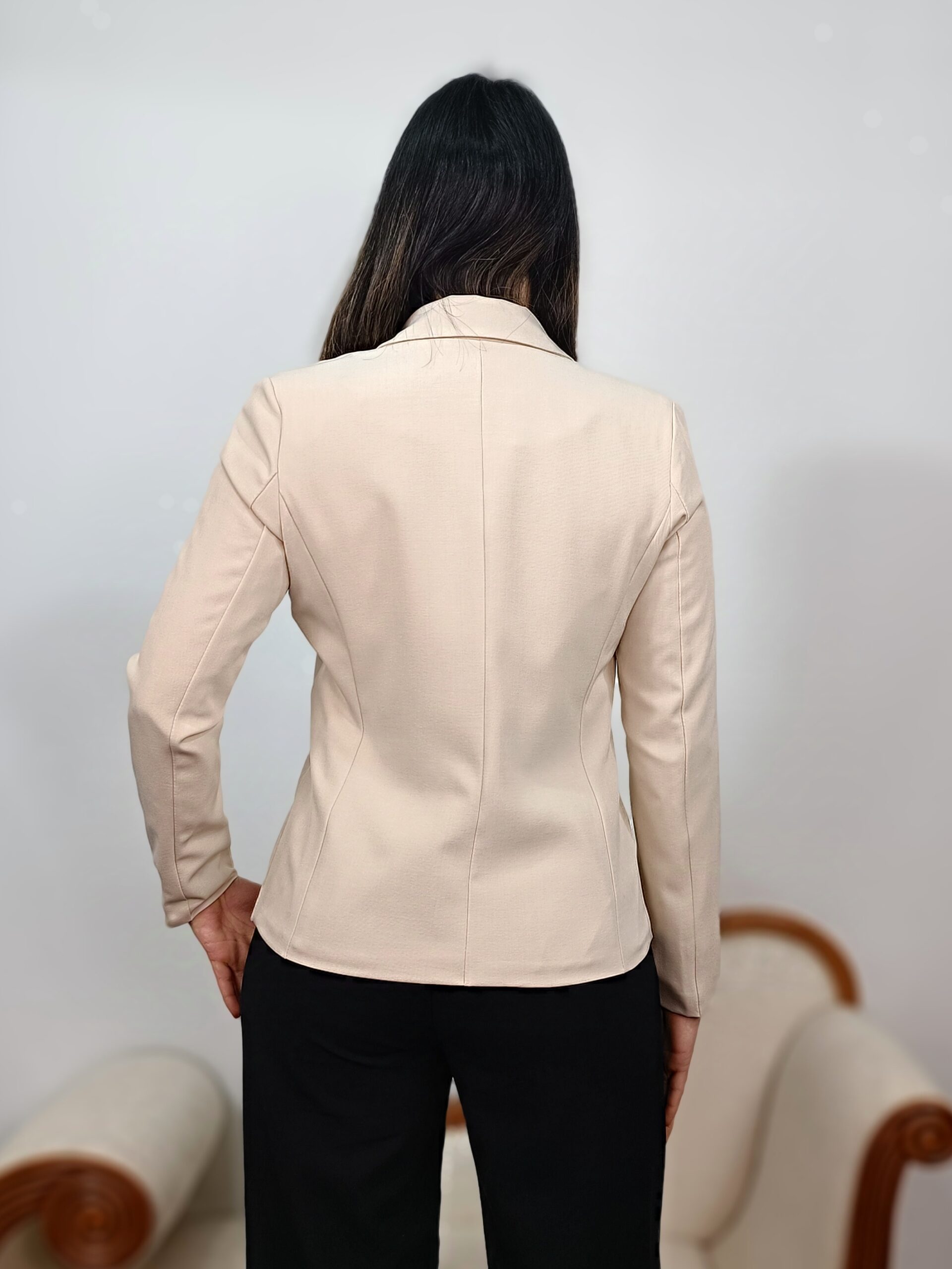 Detalle del botón a tono y la solapa clásica de la americana sastre beige.