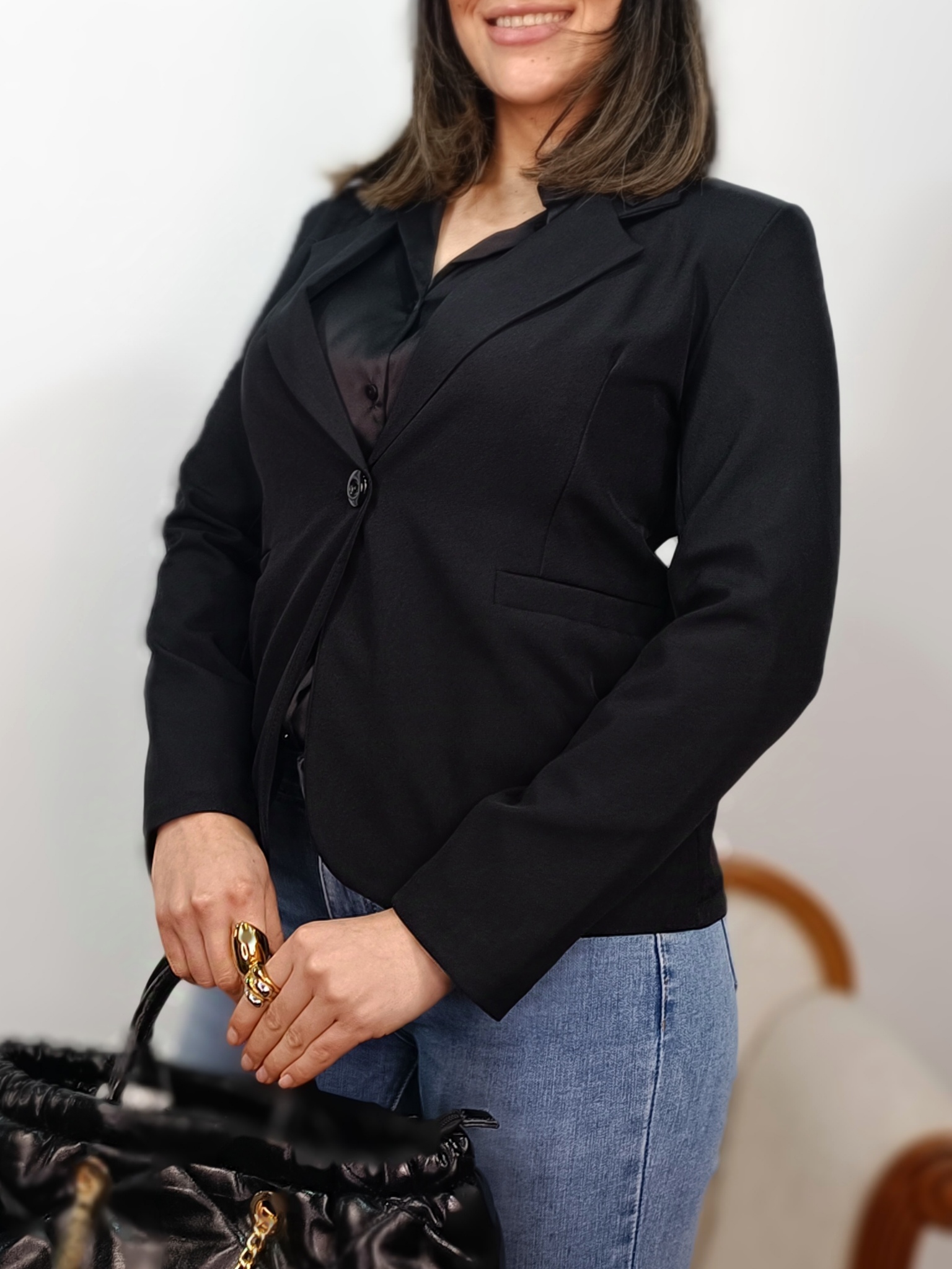 Perfil de la americana sastre negra resaltando la manga y el hombro estructurado.