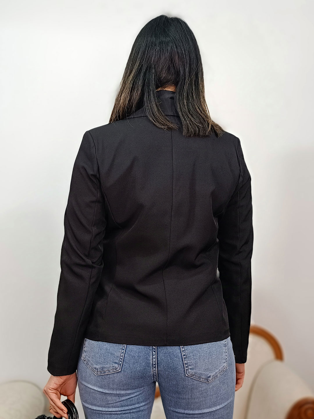 Espalda de la americana sastre negra mostrando las costuras de ajuste.