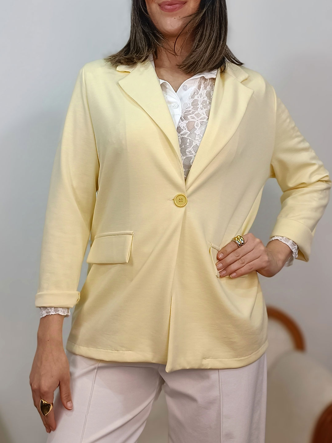 blazer punto amarillo pastel combinada con blusa de encaje blanca