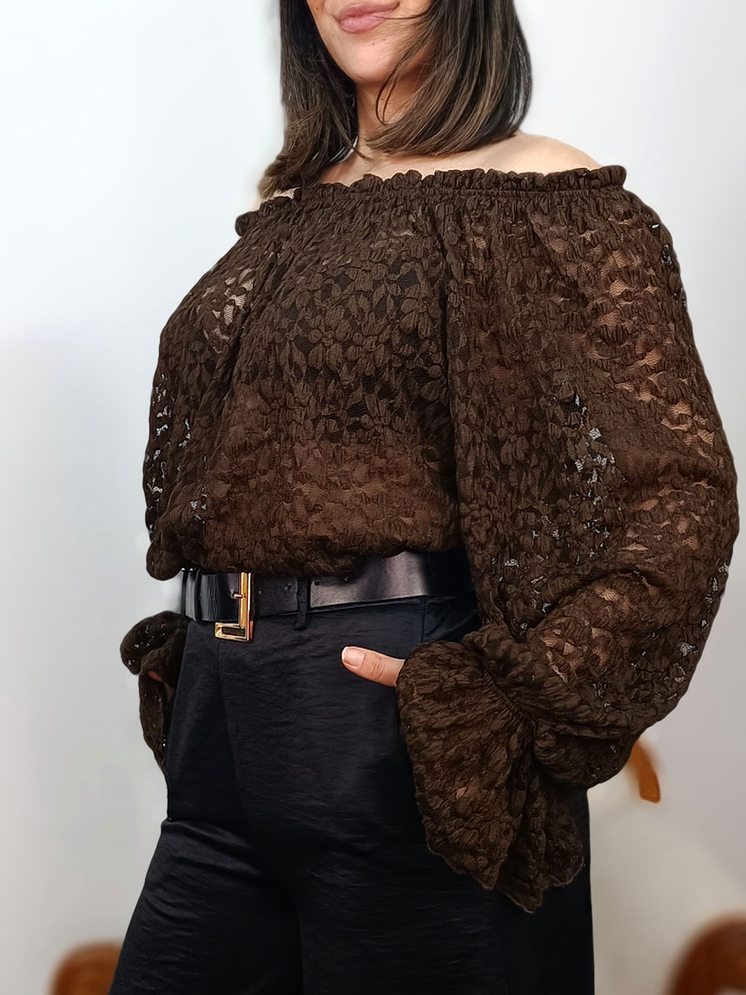 Perfil de la blusa de encaje marrón y manga abullonada.