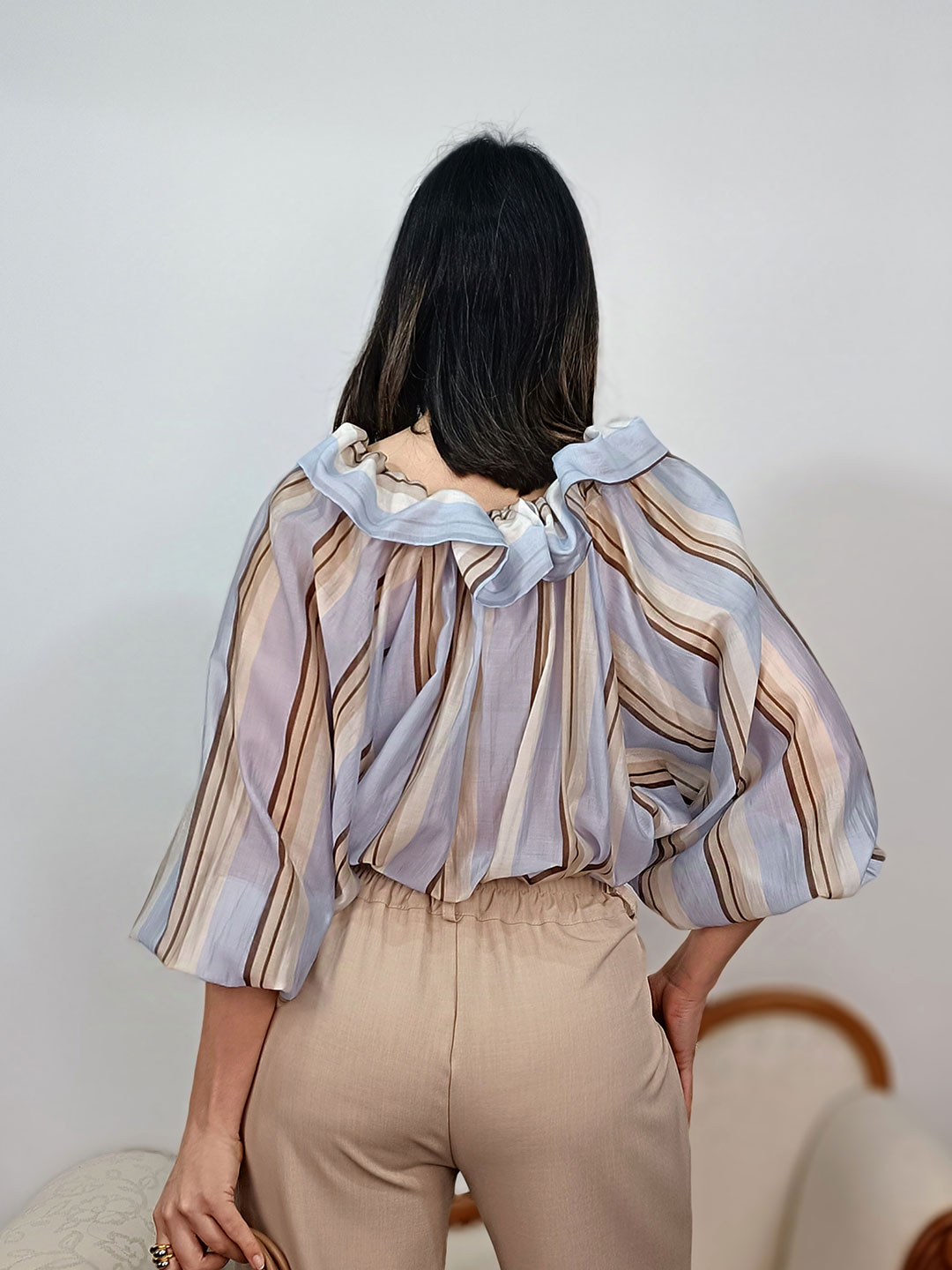 Vista posterior de la blusa de rayas azul con detalle de cuello fruncido