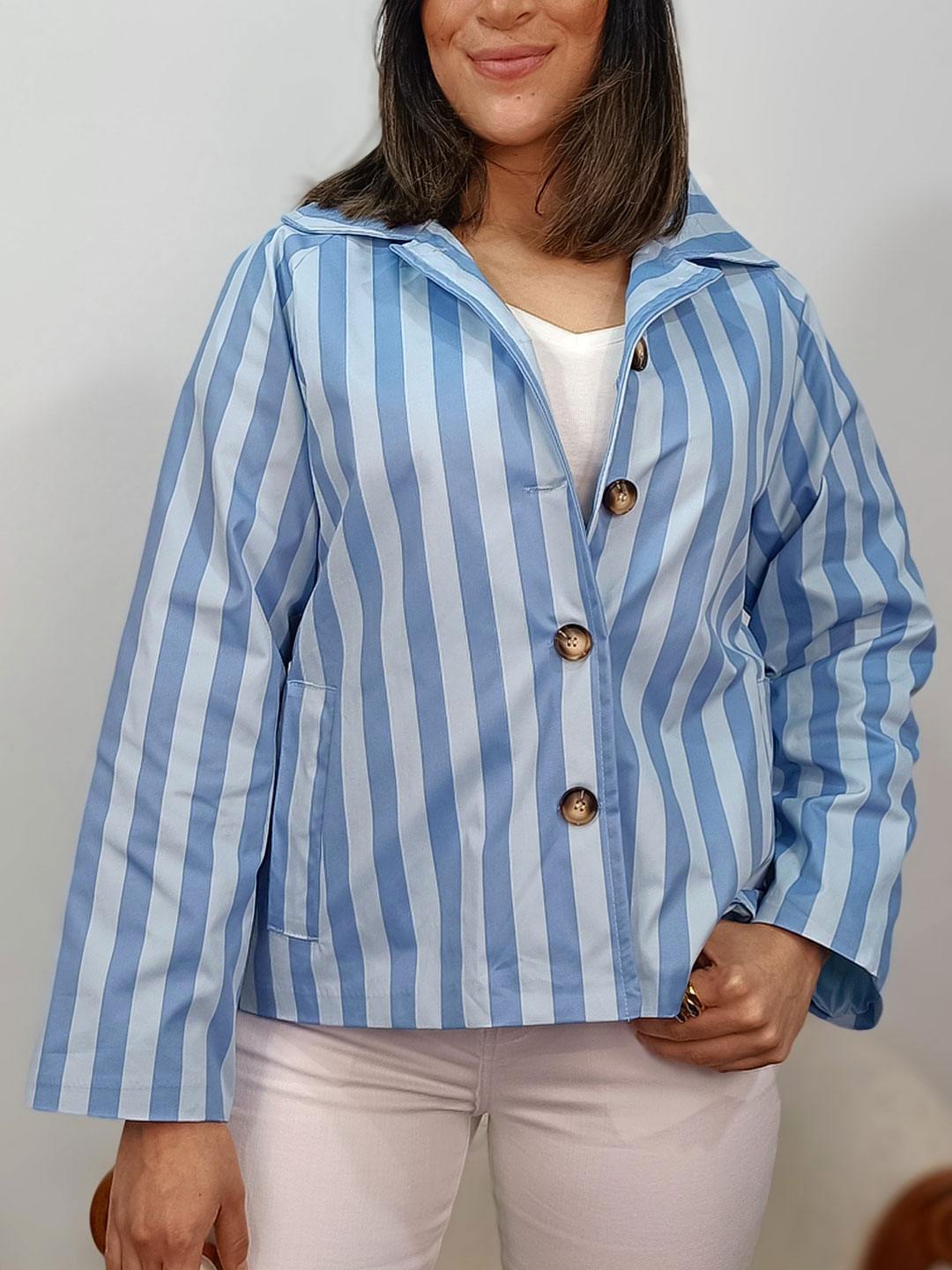 chaqueta corta azul de rayas verticales anchas con botones grandes en contraste.