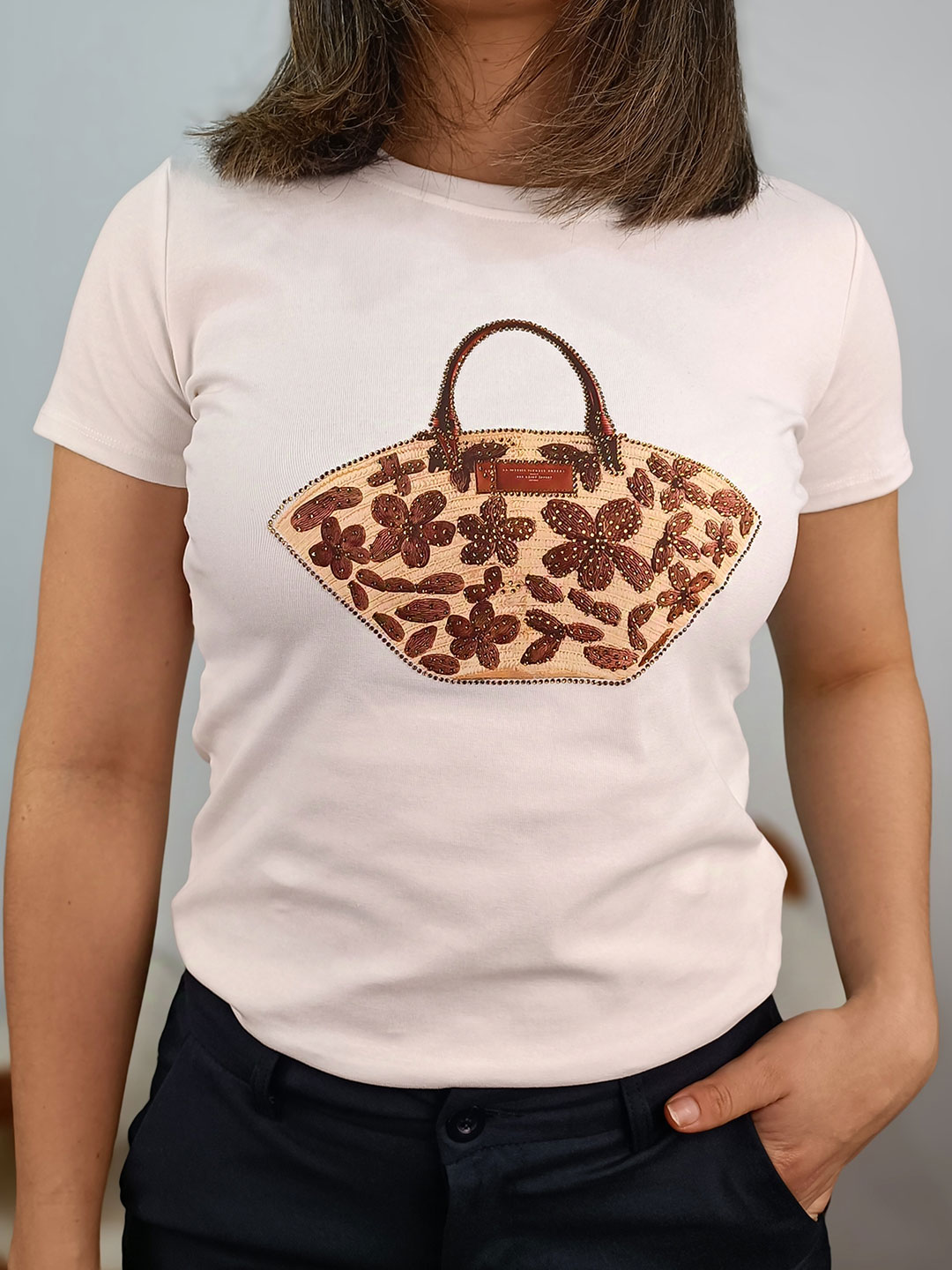 Primer plano de las flores bordadas y el capazo en la camiseta