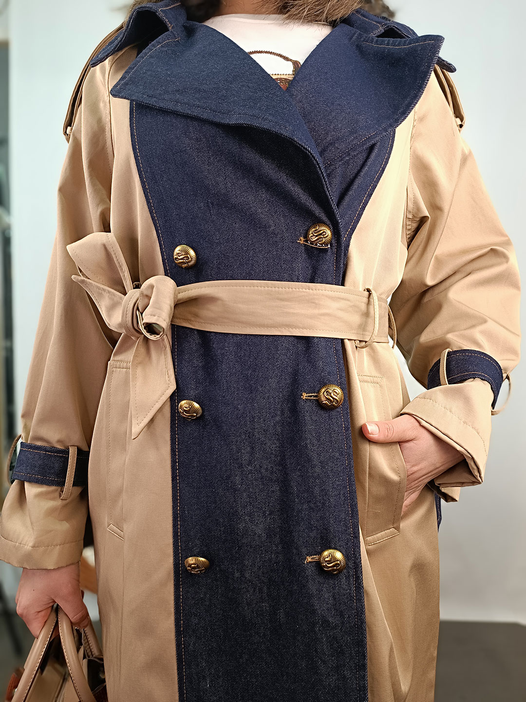 Primer plano de botones y tejido de la gabardina beige combinada denim.