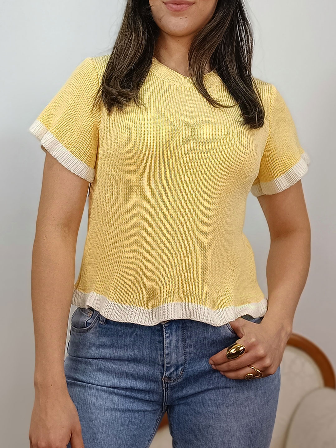 jersey de punto amarillo de manga corta con detalles de ribetes blancos.