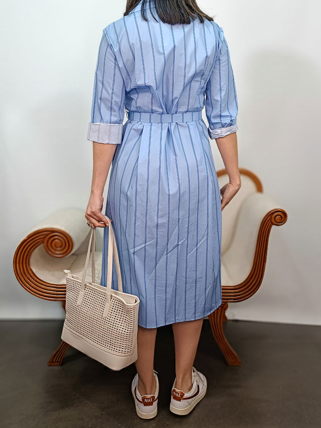 Detalle del cinturón con hebilla cuadrada del vestido camisero azul de rayas.