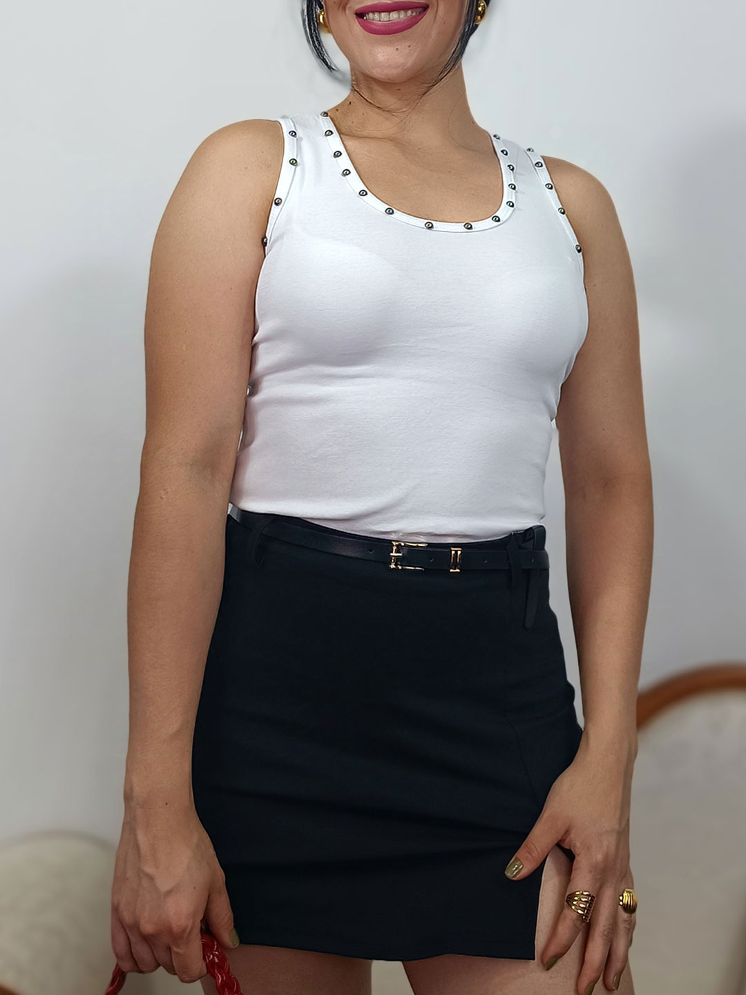Tachuelas esféricas en escote de top blanco
