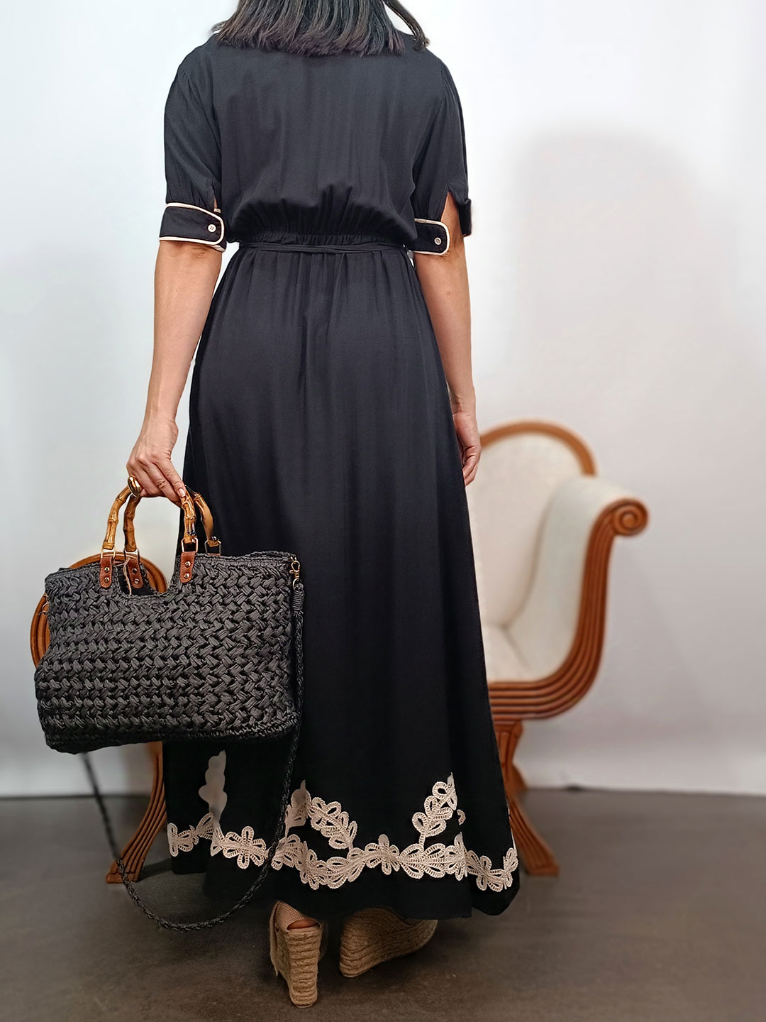 Espalda de vestido largo negro con bordados de cordón en el bajo