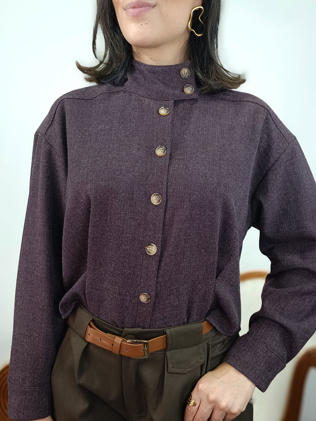 Primer plano del cuello alzado abotonado y textura en camisa morada